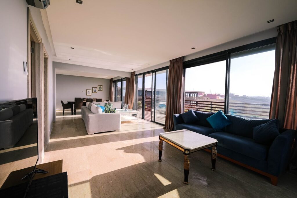 Bright and airy contemporary living room with furniture and large windows overlooking a city view.