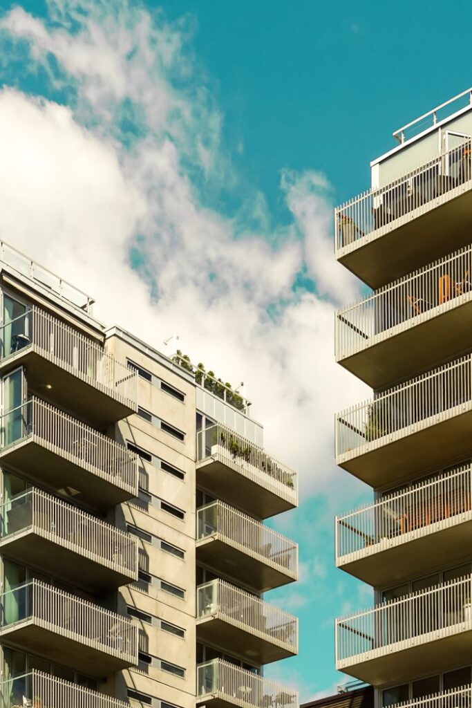 Low angle shot of modern apartment buildings with balconies in Oslo, Norway against a clear blue sky.